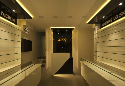 Small warm decorated mobile phone shop interior design with glass accessories display shelves and counter